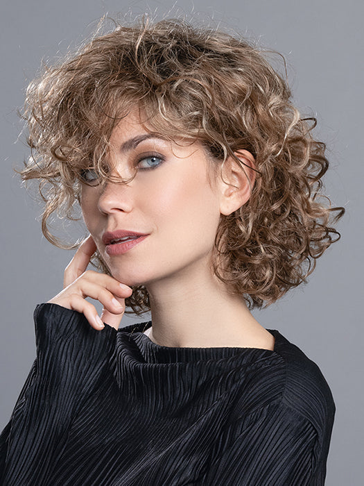 Side view of Loop wig by Ellen Wille – a curly, synthetic style from the Changes Collection. Colour Tobacco Rooted.