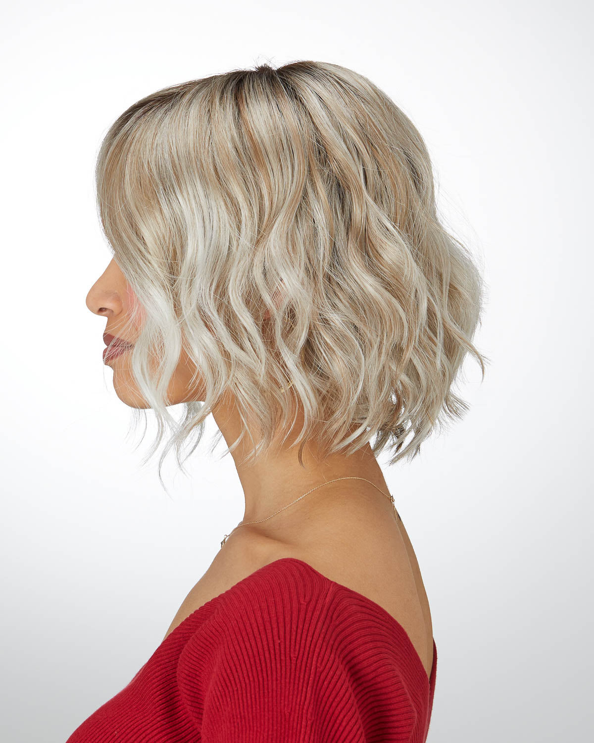 Woman with styled blonde wavy wig on a white background
