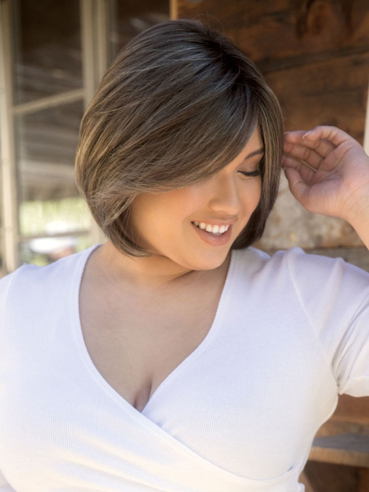 Side view Sybil wig by Amore – long layered bob with face-framing side fringe and natural-looking shape-enhancing layers.