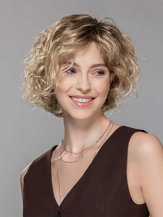 Amor Mono Part by by Ellen Wille - a curly bob style with a mono part and lace front in Sandy Blonde Rooted.