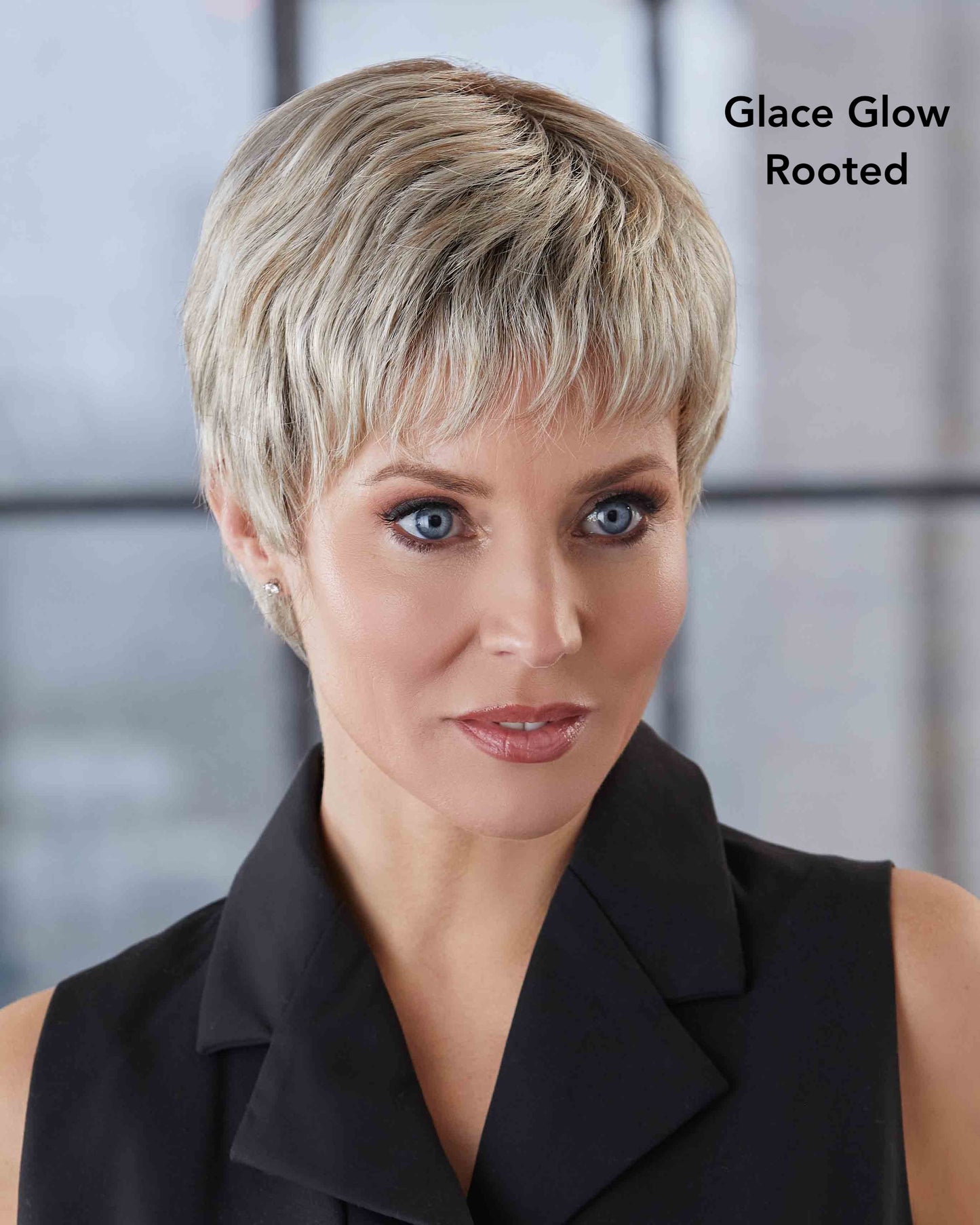 Woman with short blonde hair styled in a pixie cut, wearing a black top.