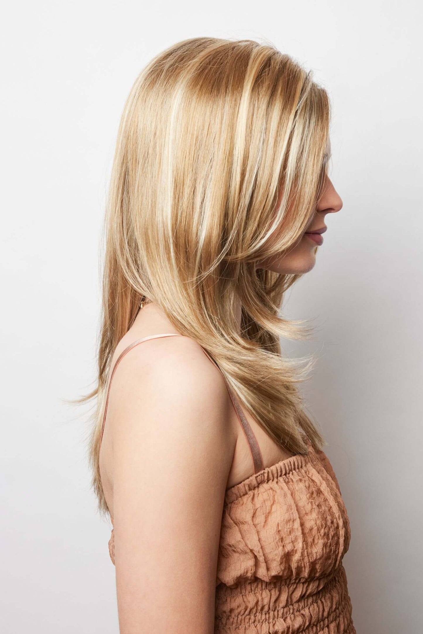Side view of Brandi wig by Amore in Creamy Toffee-R with extra-long layers that frame the face and neck.