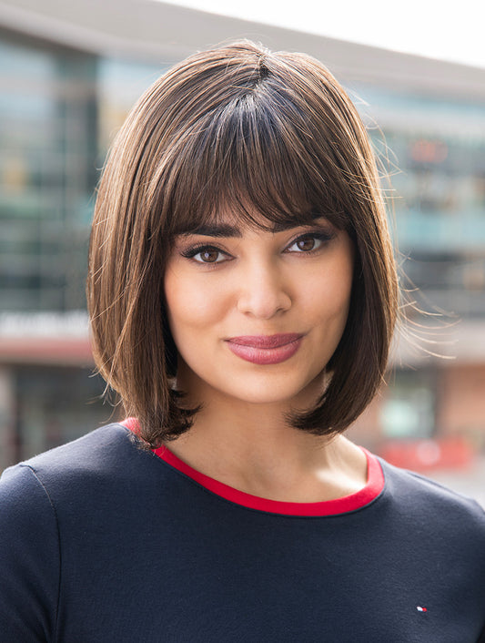 Carley wig by Envy in rooted brunette – soft face-framing layers, wispy fringe and natural movement with monofilament top construction