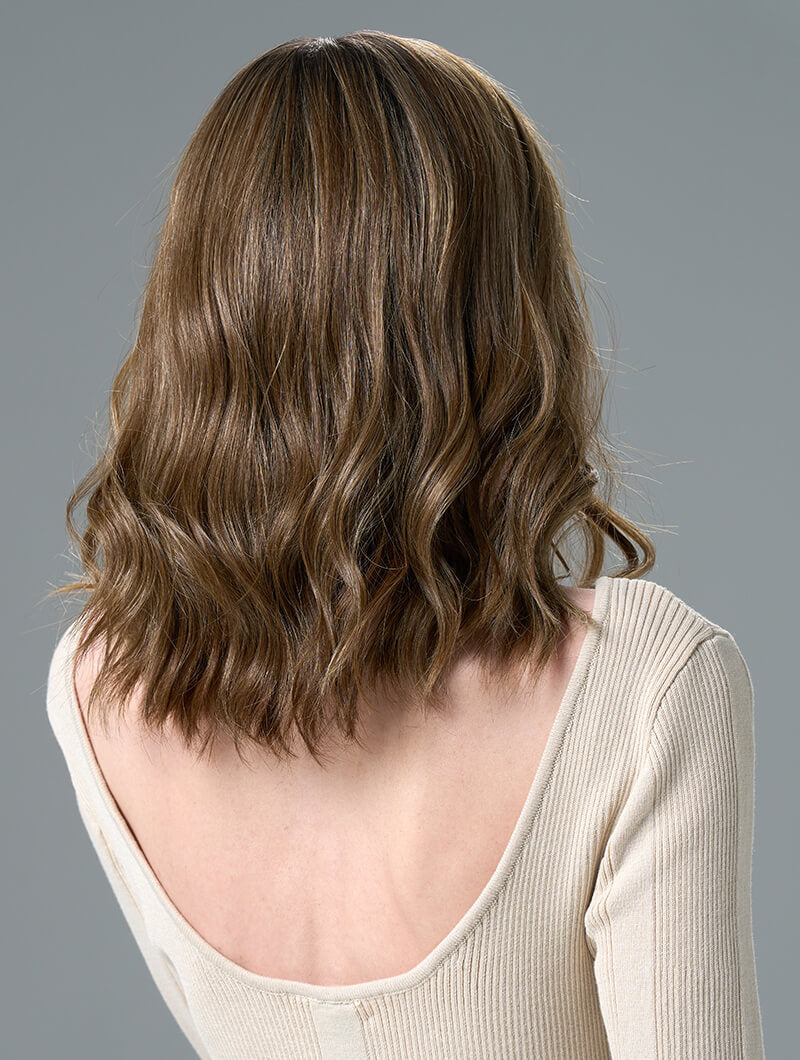 Back view of Corey wig with soft waves in Honey Breeze made from heat-friendly EnvyHair and featuring a natural lace front 
