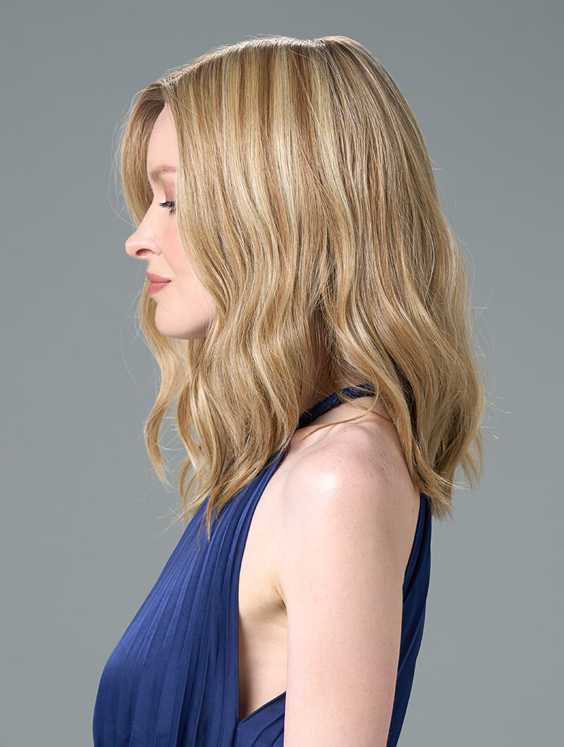 Side view of Corey wig with soft waves and face-framing layers, made from heat-friendly EnvyHair and featuring a natural lace front.