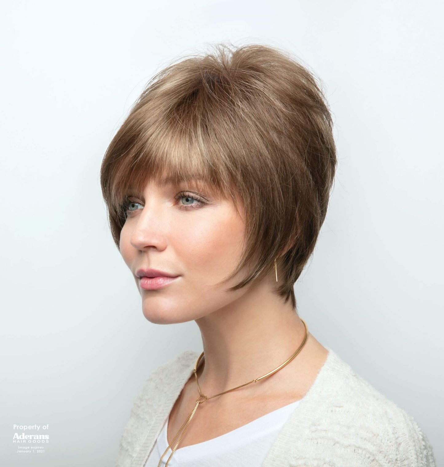 Side view of Emily wig by Amore in Honey Wheat with double monofilament cap is in a wavy short style.