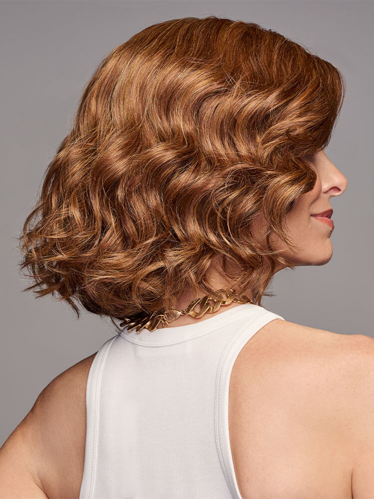 Side profile - In Bloom Wig by Gabor with soft, bouncy waves and heat-friendly synthetic hair in Medium Red.